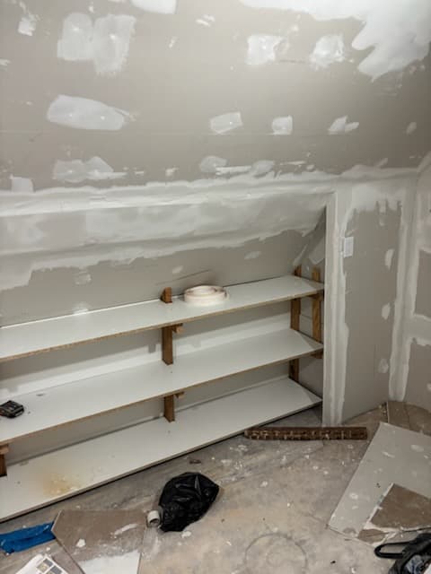 During: the built-in bookshelf taking shape while taping and skim coating continue.