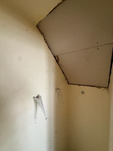 During: hanging drywall over the strapping on the wall framing.