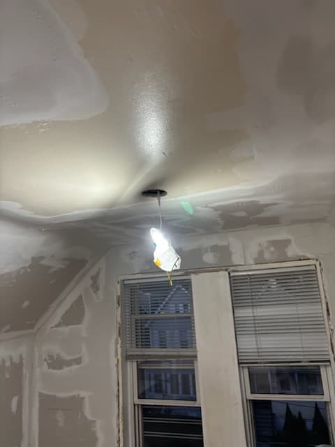 During: hanging drywall on the flat front-room ceiling.