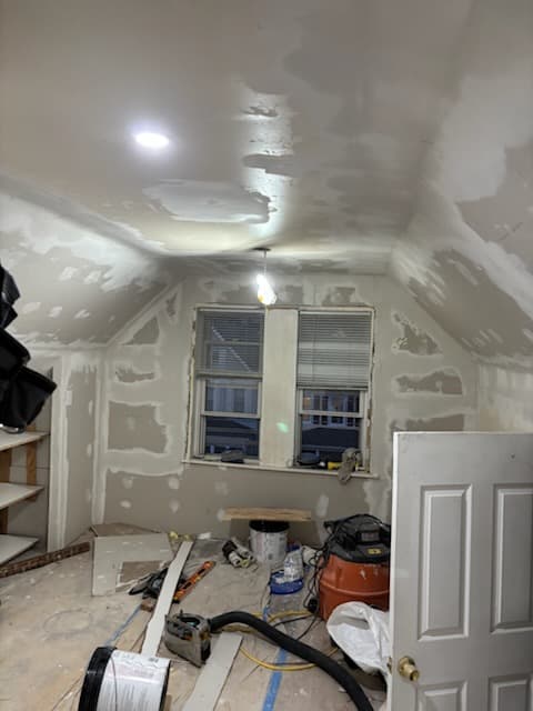 During: priming the finished drywall before paint.