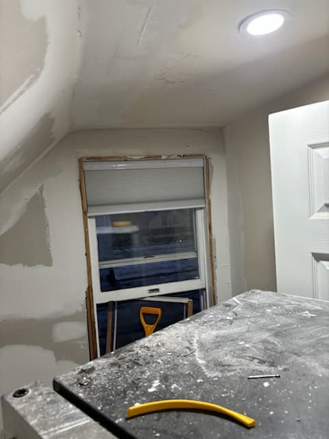 During: skim coating the knee wall ahead of the bookshelf build.