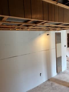 During: cement board along the base of a basement wall.