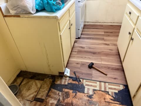 During: luxury vinyl plank going down over the leveled subfloor in the kitchen.
